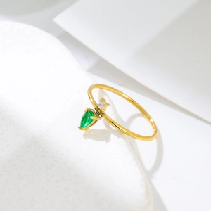 Detailed macro view of pear-cut green zircon and small round stone on gold titanium ring