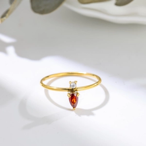 Elegant gold titanium steel ring with a pear-cut red zircon and round clear stone accent