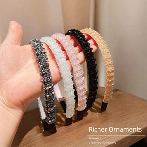 Detail of five handmade crystal bead headbands in silver, white, pink, black and amber gold