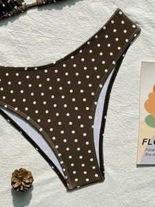 Dettaglio dello slip bikini a vita alta a pois marrone scuro su tessuto testurizzato
