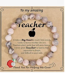 Detail view of pink stone bead bracelet with apple charm on teacher gift card