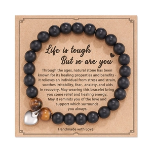 Close-up of handmade beaded heart bracelet on craft card with motivational text