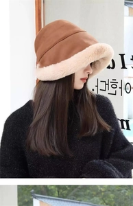 Detail of winter fisherman hat with brown fabric and thick beige plush faux fur trim