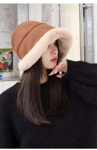 Detail of winter bucket hat showing brown suede and white faux fur texture in close-up