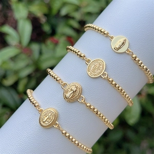 Classic 18K gold plated beaded bracelets with religious pendants on white stand