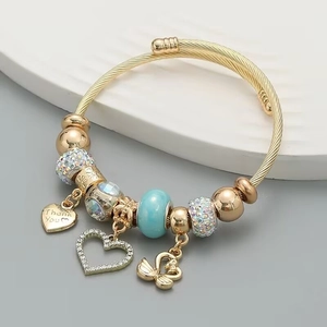 Adjustable golden stainless steel bracelet with swan and heart charms and crystal beads