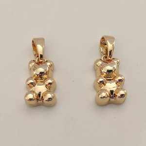 Close-up of dual golden resin gummy bear pendants with high-polish mirror finish