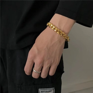 Hip hop style gold Cuban link bracelet and silver ring set worn by model