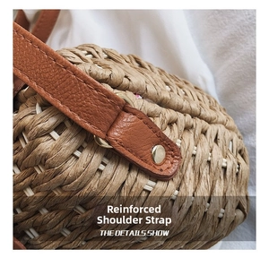 Detail of brown faux leather shoulder strap with gold rivets on straw woven bag