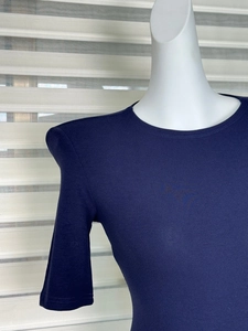 Detailed view of navy blue slim-fit knit top featuring padded shoulders and a round neck