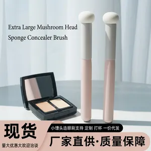 Close-up of oversized mushroom head sponge concealer brushes with pink long handles