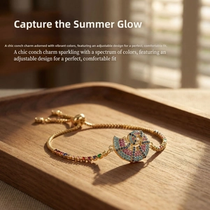 Detail of adjustable gold shell bracelet with colorful pavé zircons on wooden tray