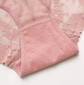 Dettaglio di slip in pizzo rosa con delicati motivi floreali e tessuto a rete traspirante