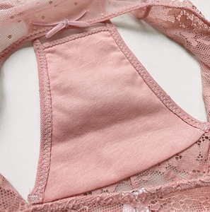 Dettaglio ravvicinato di slip in pizzo rosa con ricamo floreale e fiocco