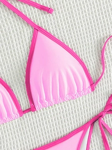 Close-up of pink color-block bikini top with pleated cups and satin finish detail