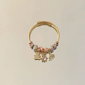 Golden spiral charm bracelet with pink crystals, diamond teddy bear and heart charms