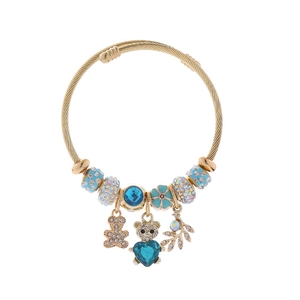 Detail of gold charm bracelet with blue heart bear pendant and iridescent faceted beads