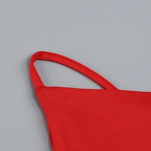 Detail of red resort dress showing fine stitching on thin shoulder straps and texture