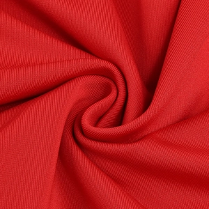 Close-up of bright red knitted fabric showing fine texture and flexible drape detail