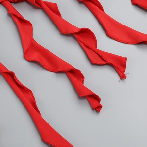 Close-up of bright red chiffon ruffles with precise overlock edge stitching and soft texture