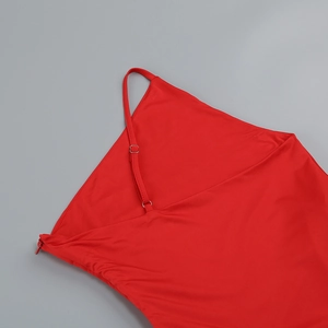 Detail of red dress with adjustable spaghetti straps, metal buckles, and a side zipper