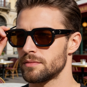 Détail de lunettes de soleil carrées polarisées avec ornements en T dorés sur un mannequin