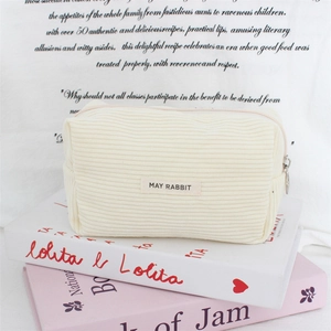 Macro detail of cream corduroy storage bag with zipper and May Rabbit woven label