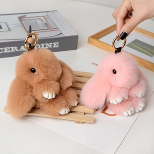 Detailed close-up of brown and pink plush bunny keychains with soft faux fur texture
