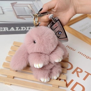 Close-up of pink plush bunny keychain with long ears and gold stitched feet detailing
