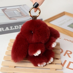 Detail of red plush rabbit keychain featuring soft faux fur and shiny gold metal ring