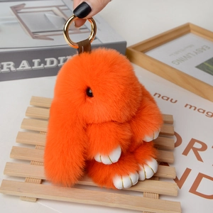 Detail of soft orange plush bunny keychain with fluffy texture and gold metal ring