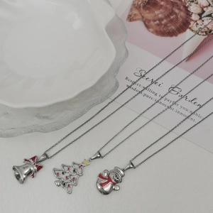 Close-up of Christmas tree, bell, and snowman enamel pendants on silver-tone necklaces