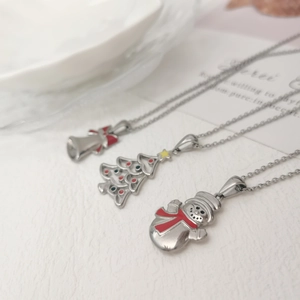 Macro detail of silver stainless steel necklaces with snowman tree and bell pendants