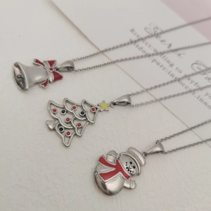 Detail of Christmas necklaces featuring silver bell, festive tree, and snowman pendants