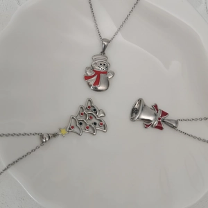 Detailed view of colorful Christmas tree, snowman and bell pendants on a white plate