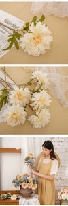 Macro detail of artificial cream dahlia petals with realistic green foliage for home decor