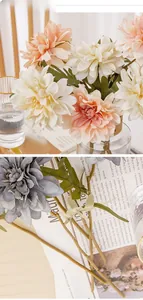 Detail of artificial dahlia flowers in glass vase and on vintage newspaper background