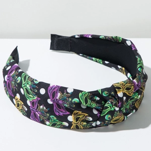 Detail of twisted fabric headband with colorful carnival masks and white polka dots