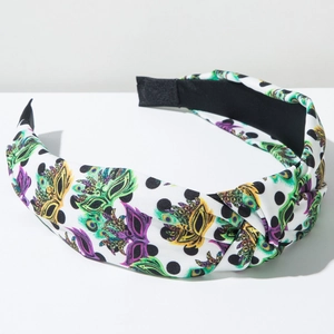 Detailed view of white polka dot headband with colorful carnival mask print pattern