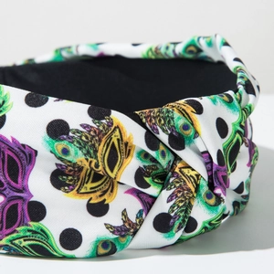 Macro shot of twisted knot headband featuring polka dots and vibrant peacock feather prints