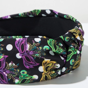 Detail of Mardi Gras knotted headband featuring colorful festive masks and peacock patterns
