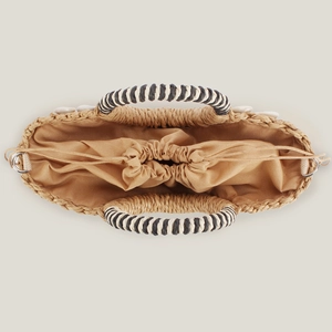 Top view of a woven shell handbag with drawstring closure and decorative handles