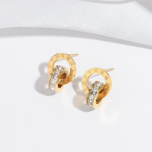 Macro detail of gold-plated double hoop earrings with Roman numerals and white zircons