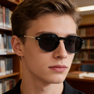 Detail of polarized sunglasses with black frames and gold-tone metal temples on a model