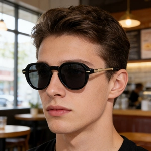 Side view of man wearing vintage black sunglasses with gold metal temples and arrow rivets