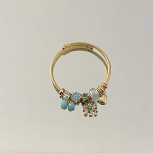 Gold spiral charm bracelet featuring pink elephant, blue floral and heart pendants