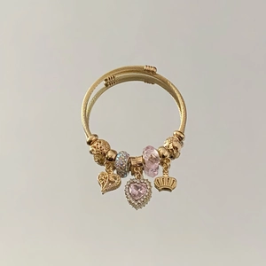 Detail of gold heart charms and pink crystal beads on adjustable bangle bracelet