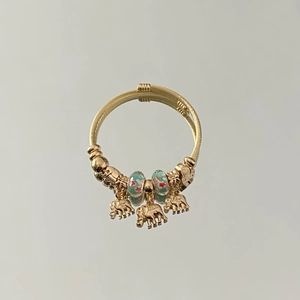Detail view of gold beaded bracelet featuring elephant charms and blue floral glass beads