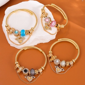 Dettaglio di quattro bracciali a spirale dorati con perline di cristallo e cuori
