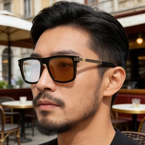 Detail of men's square black glasses with photochromic lenses and gold temple accents
